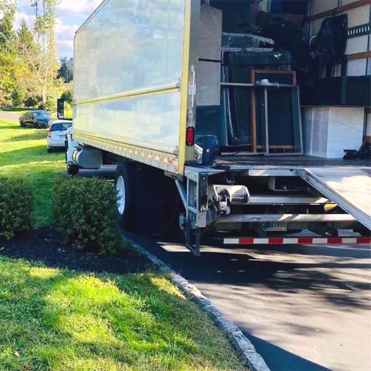 A CarePhilly truck with its liftgate down, loaded with furniture