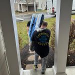 CarePhilly Movers Employees moving a large tv