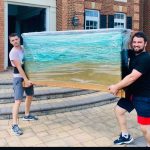 CarePhilly Movers Employees moving a fishtank
